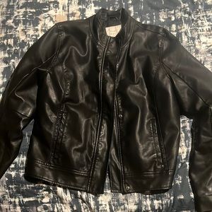 Faux leather coat. With pockets outside. Fake zipper out the hands.